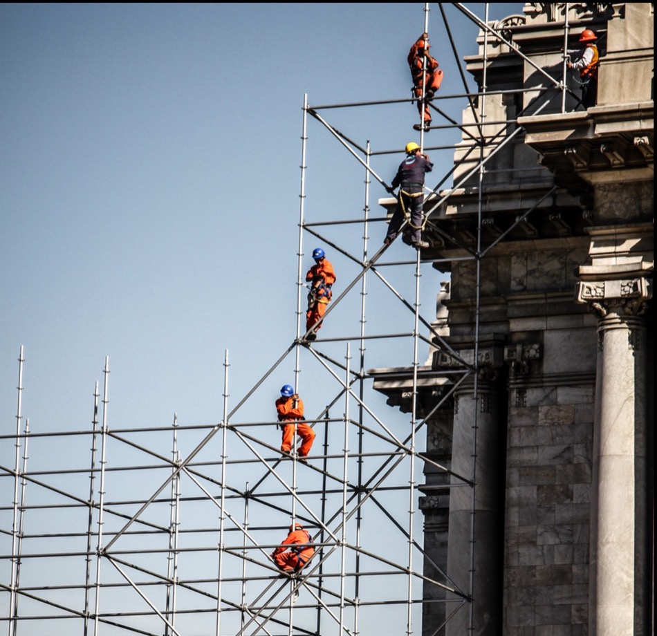 Trabajadores en andamios durante obra exterior